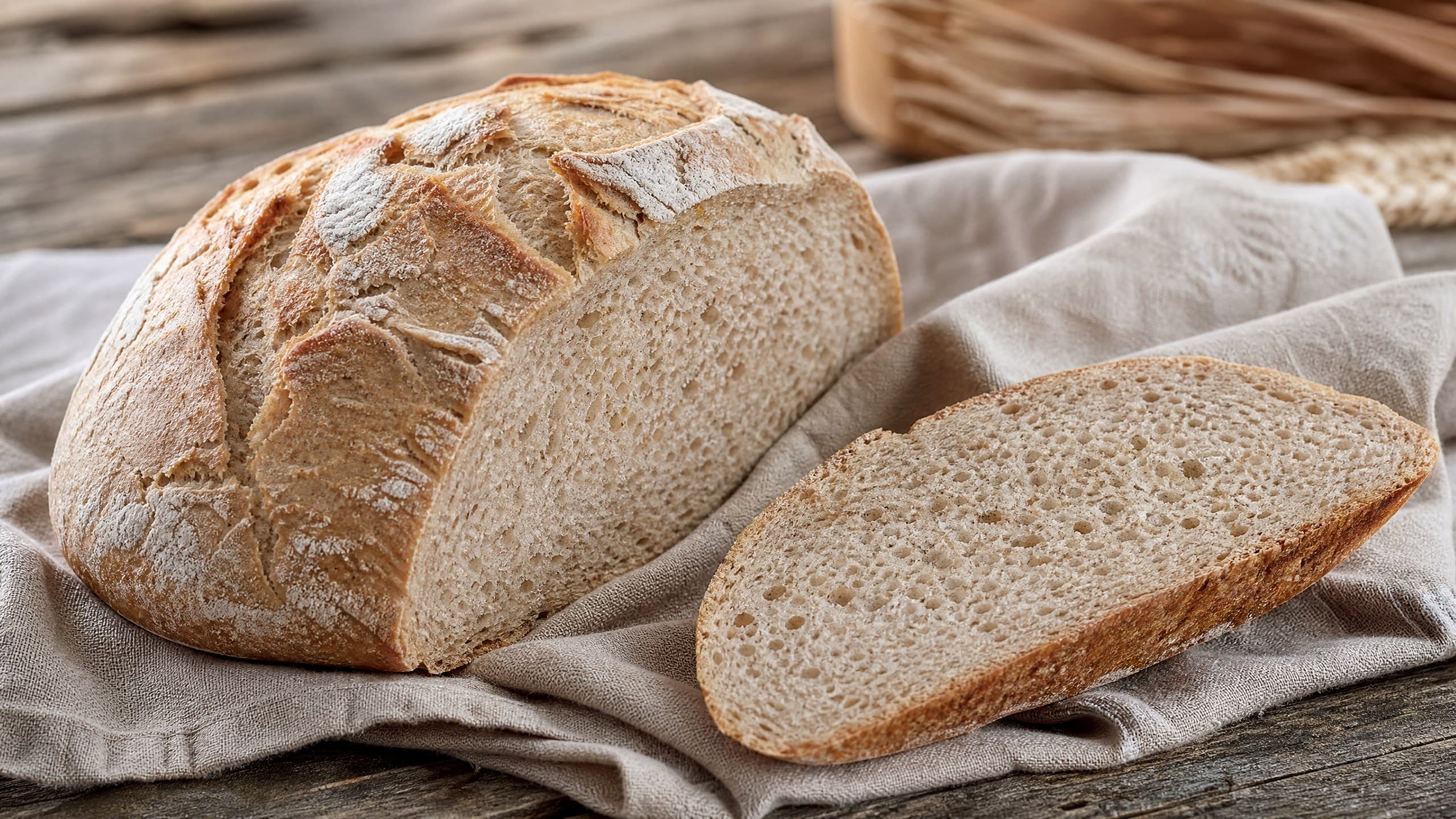 Freshly baked sourdough spelt bread: nutty, tender, lower gluten, photographed on a warm cream background