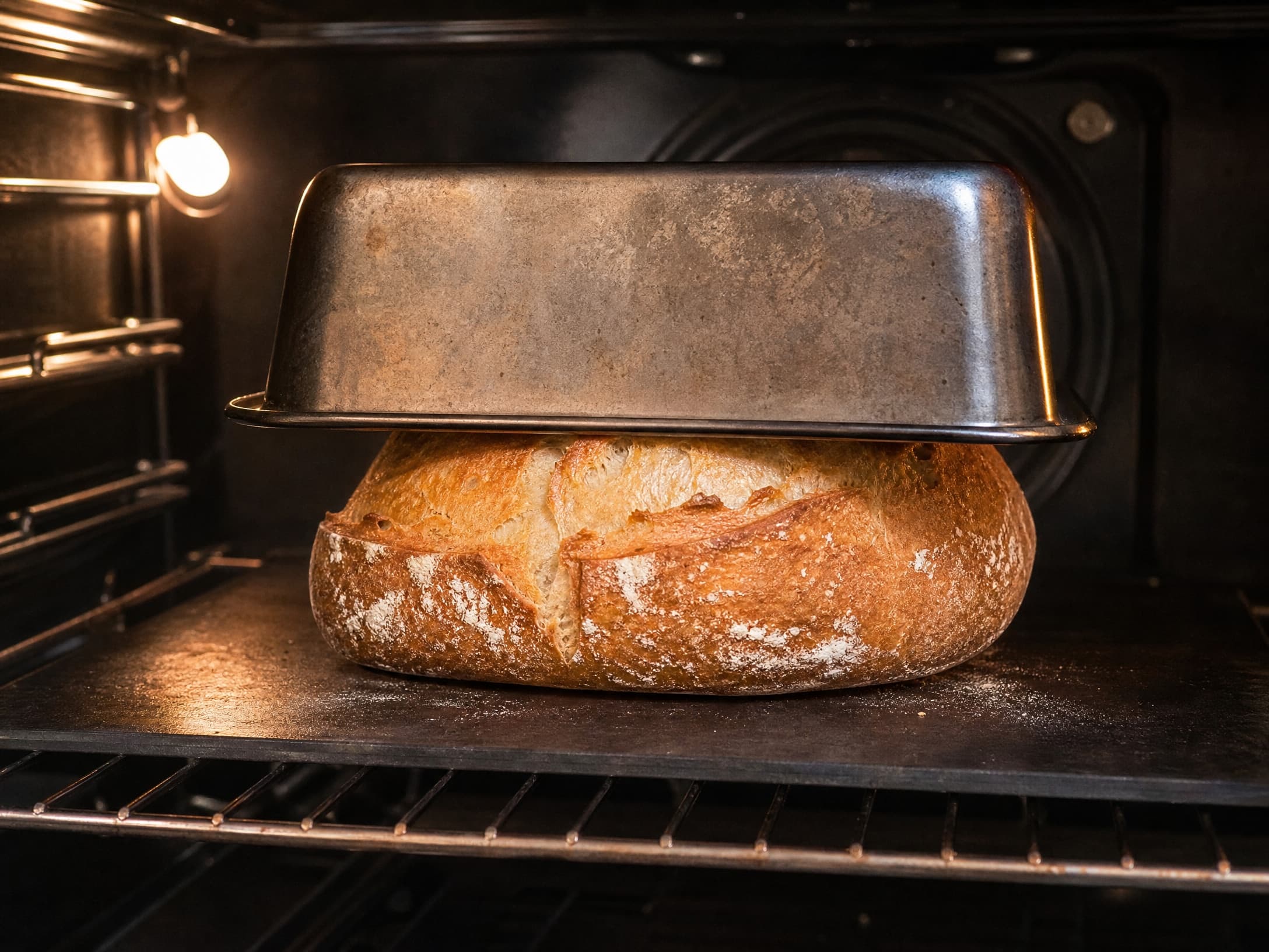Sourdough loaf baking under an inverted loaf pan as a lid
