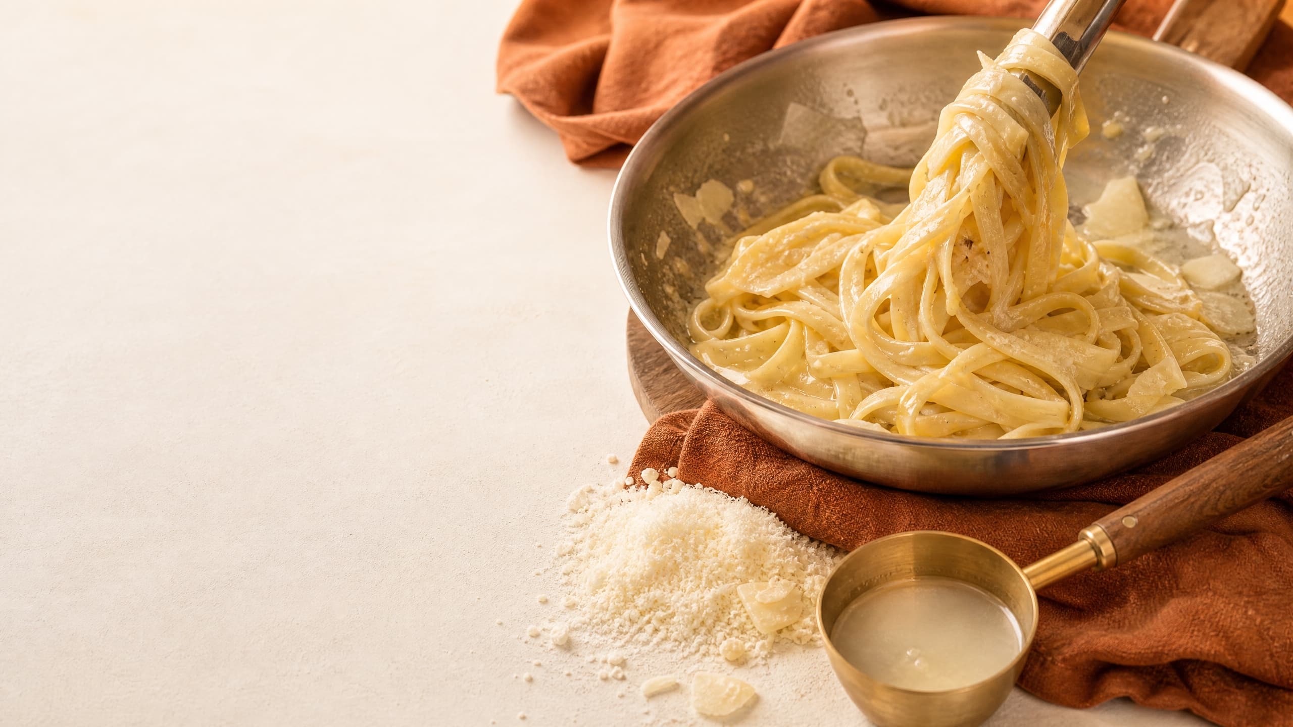 Freshly baked authentic alfredo sauce (no cream, 3 ingredients), photographed on a warm cream background