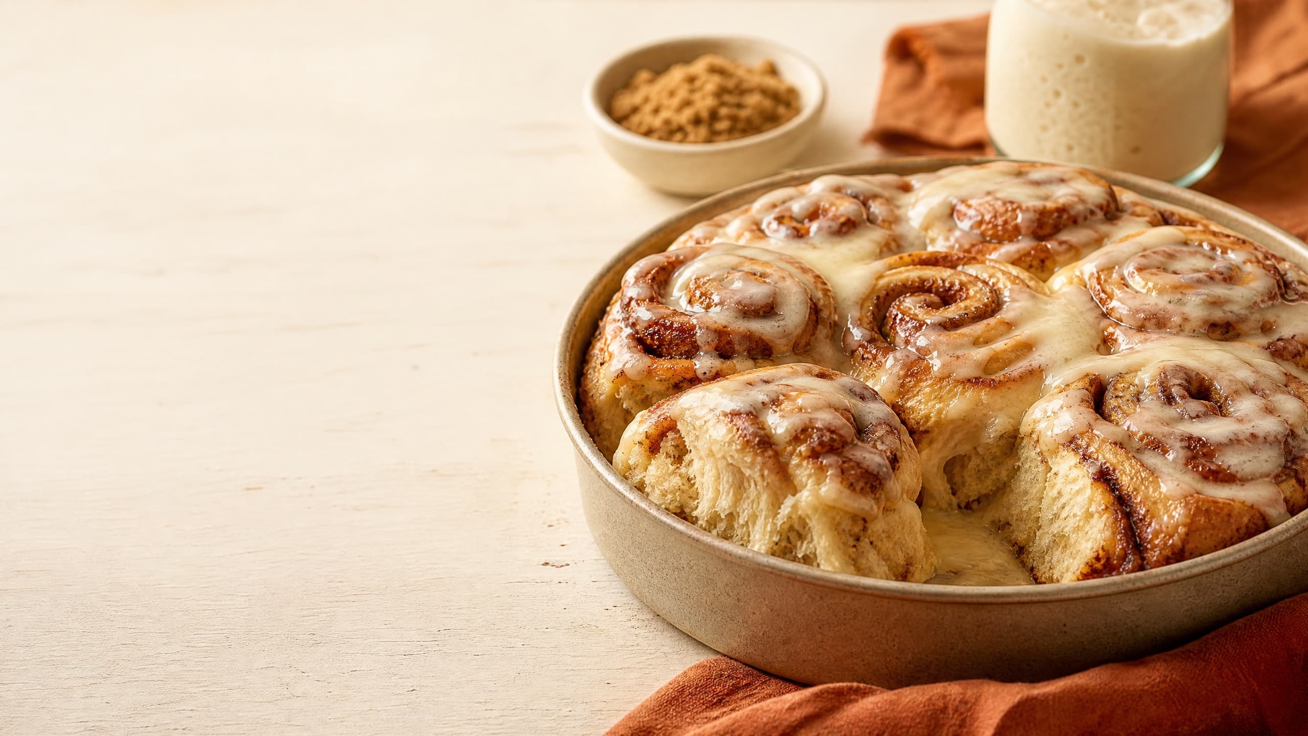 Freshly baked sourdough cinnamon rolls, photographed on a warm cream background